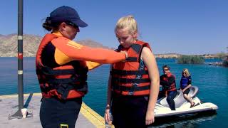 Person helping person with life jacket